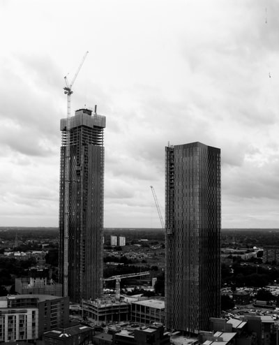 Both buildings in this image lay on thirds. By doing this they are evenly spaced as they are the same distance from the edge of the image on either side. The horizon is placed on the lower. The white sky highlights the buildings so they don't get lost in the mass of other grey buildings below, highlighting them as the subject of the image. 
